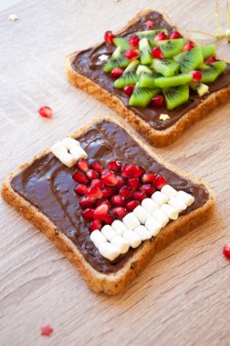 Noel sağlıklı kahvaltı veya tatlı fikir çocuklar - krem çikolata, nar Santa şapka ve kivi Noel ağacı, tost için en iyi görünümü