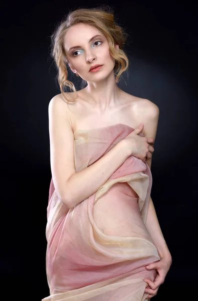 Mooie vrouw gedrapeerd in transparante jurk. — Stockfoto