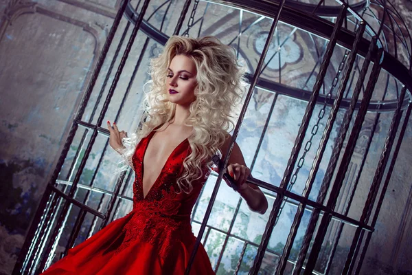 Mode blonde in rode jurk met pluizige rok in de buurt van de vogelkooi, begrip van bevrijding — Stockfoto