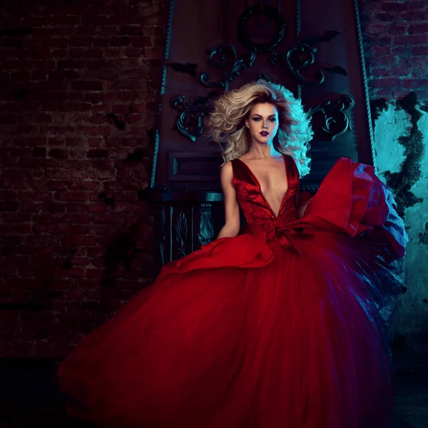 Fashion photo of young magnificent woman. Running towards camera. Seductive blonde in red dress with fluffy skirt — Stock Photo, Image