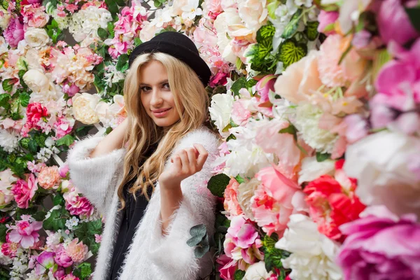 Mulher loira bonita nova no chapéu na moda em fundo floral — Fotografia de Stock