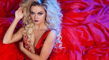 Kırmızı elbiseli genç muhteşem kadın moda fotoğrafı. Stüdyo portre