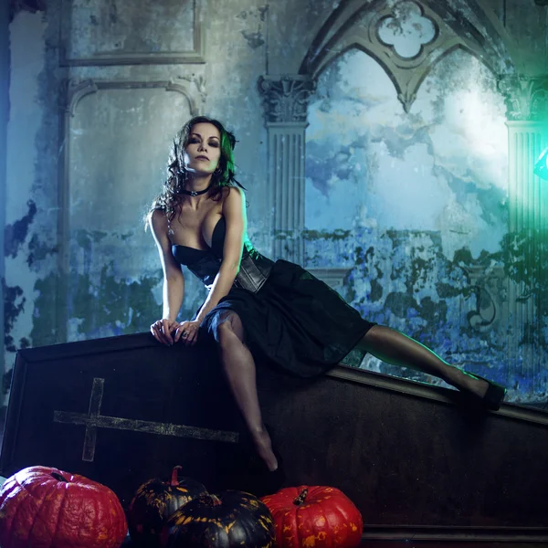 Genç ve seksi kadın, görüntü kapak tabut üzerinde oturan bir mezarlık'da cadıların. — Stok fotoğraf