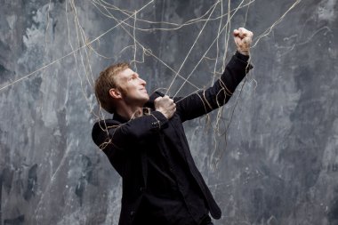 Genç adam zincirleri kırmaya çalışan. Kavramı manipülasyon ve kölelik