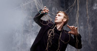 Genç adam askıları makasla kesmek çalışır. Manipülasyon kurtuluş kavramı