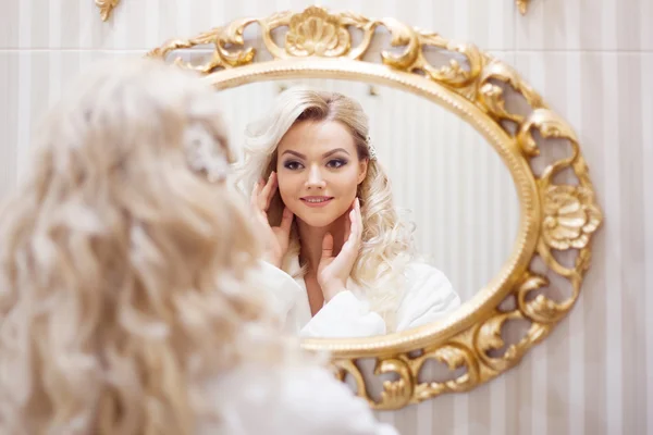Porträtt av ung sexig kvinna i morgonrock tittar på spegeln. — Stockfoto