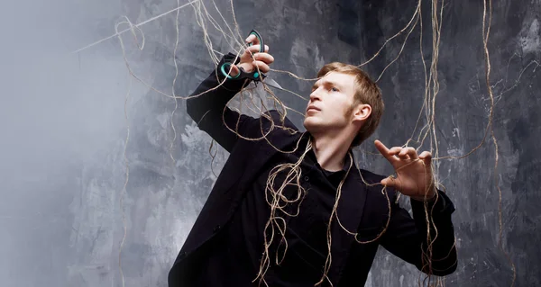 Genç adam askıları makasla kesmek çalışır. Manipülasyon kurtuluş kavramı