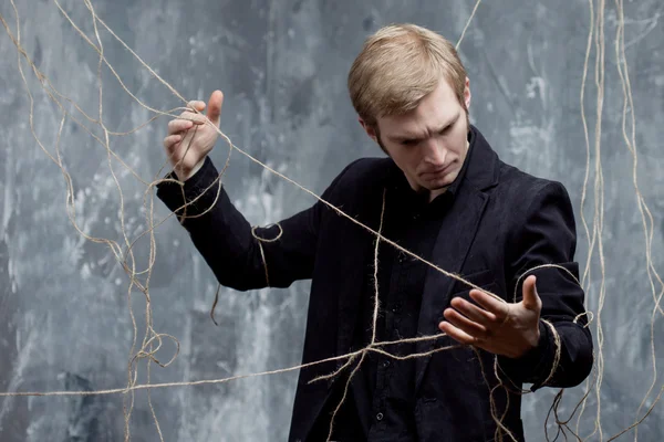 Young man tries to break the shackles. Concept of manipulation and slavery — Stock Photo, Image