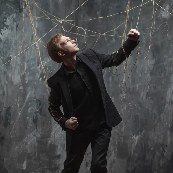 Young man pulling something behind him. Concept of manipulation and slavery — Stock Photo, Image