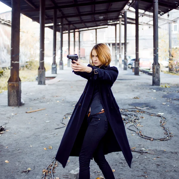 Mujer apuntando con un arma. Mafia chica disparando a alguien en la calle . — Foto de Stock