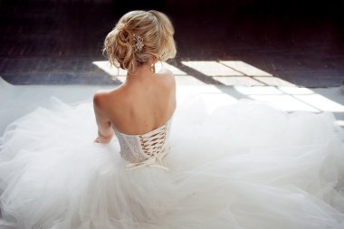 Lüks gelinlik büyüleyici genç gelin. Güzel kız beyaz. Gri arka plan. Geri