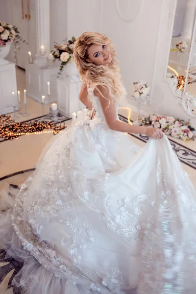 Joven novia hermosa en vestido de novia de lujo. Enorme falda hinchada con tren. Interior de luz de lujo — Foto de Stock