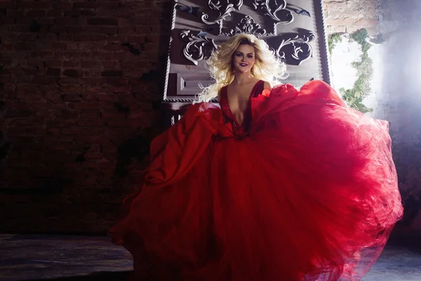 Photo de mode de jeune femme magnifique. Courir vers la caméra. Blonde séduisante en robe rouge avec jupe moelleuse — Photo