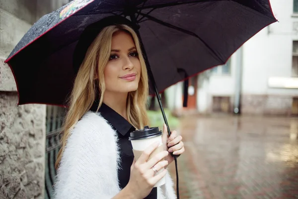 Mujer alegre en la calle bebiendo café de la mañana —  Fotos de Stock