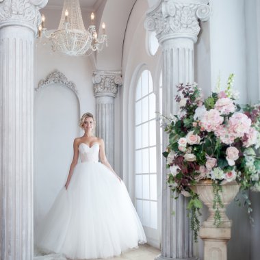 Lüks gelinlik büyüleyici genç gelin. Güzel kız, büyük penceredir