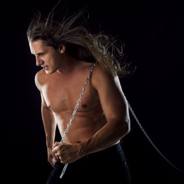 Arkasında bir şey sürükleyerek uzun saçlı genç adam. Güçlü.