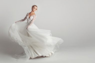 Güzel çekici gelin gelinlik uzun tam etek, beyaz arka plan ile dans ve gülümse