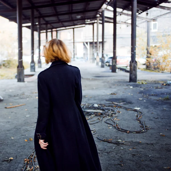 Dívka v kabátě, v trestní oblasti, zpět — Stock fotografie