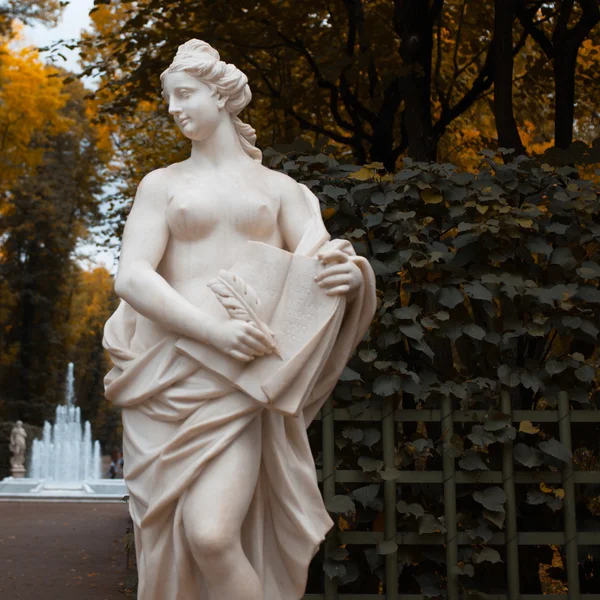 조각 공원에서. 여자는 양피지에 뭔가 씁니다. — 스톡 사진