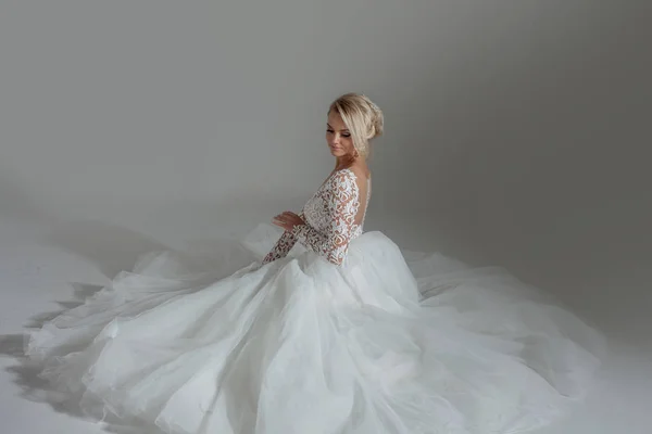 Hermosa novia en lujoso vestido de novia, sentado en círculo faldas largas. Fondo blanco, vista superior — Foto de Stock