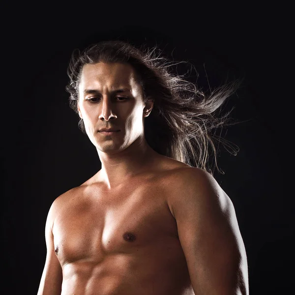 Jovem atraente do sexo masculino, tipo de corpo atlético, cabelos longos, rosto pensativo — Fotografia de Stock