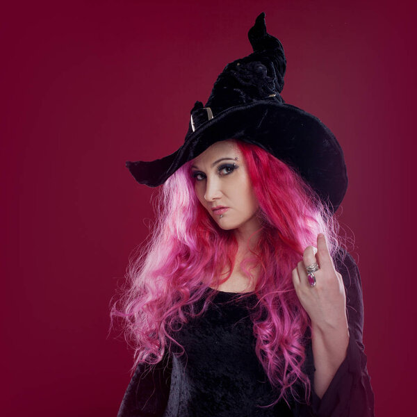 Привлекательная женщина в шляпе и костюме ведьмы с рыжими волосами. Хэллоуин
