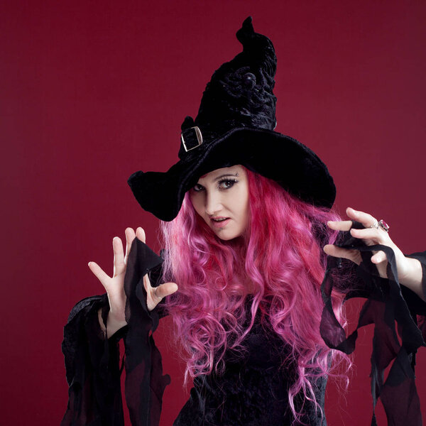 Привлекательная женщина в шляпе и костюме ведьмы с рыжими волосами. Хэллоуин
