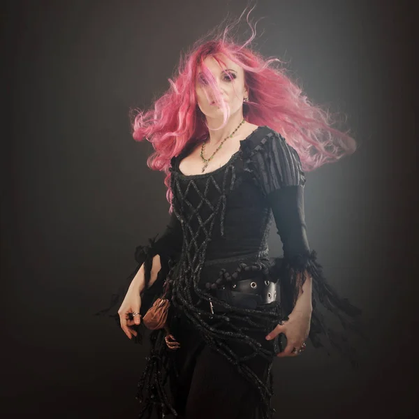 La Strega di Halloween crea magia. Donna attraente con i capelli rossi in costume streghe — Foto Stock
