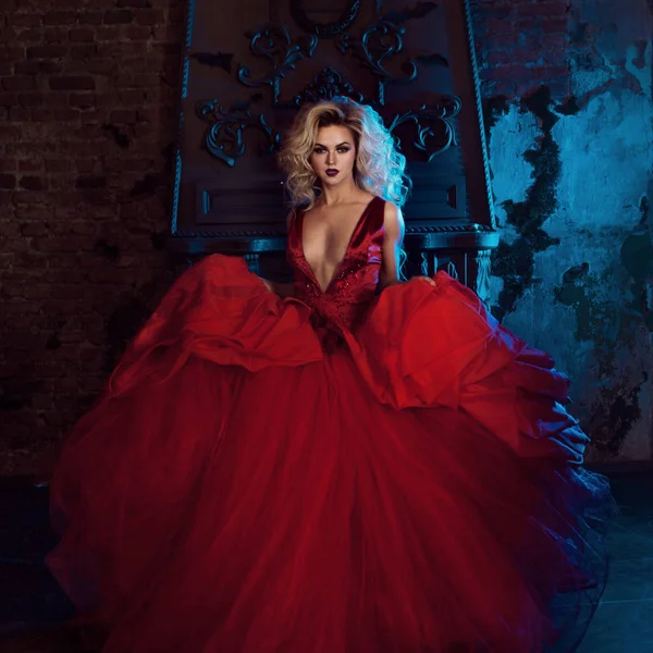 Foto de moda de una mujer joven y magnífica. Corriendo hacia la cámara. Rubia seductora en vestido rojo con falda esponjosa — Foto de Stock