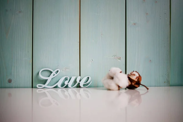 Zarten türkisfarbenen Hintergrund mit Baumwolle und Inschrift Liebe — Stockfoto