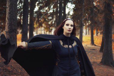 Genç güzel ve gizemli kadın ormanda hood, orman elf ya da cadı görüntü ile siyah pelerin