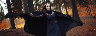 Genç güzel ve gizemli kadın ormanda hood, orman elf ya da cadı görüntü ile siyah pelerin