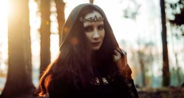 Genç güzel ve gizemli kadın ormanda hood, orman elf ya da cadı görüntü ile siyah pelerin