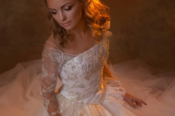 Hermosa novia chica en lujoso vestido de novia, retrato en tonos dorados, efectos de deslumbramiento — Foto de Stock