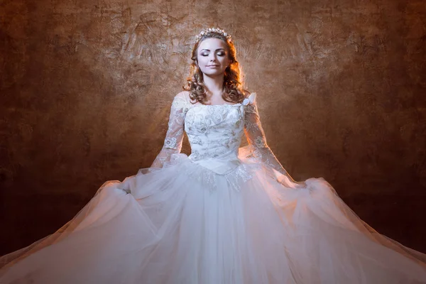 Schöne Braut im luxuriösen Hochzeitskleid, Porträt in goldenen Tönen — Stockfoto