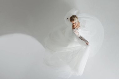 Güzel çekici gelin gelinlik uzun tam etek, beyaz arka plan, dans ve gülümseme, üstten görünüm