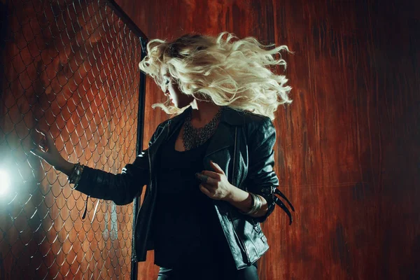 Rocknroll fille, jeune belle femme danse dans l'allée sombre, contre la clôture maille — Photo