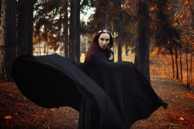 Genç güzel ve gizemli kadın ormanda hood, orman elf ya da cadı görüntü ile siyah pelerin