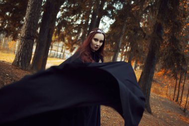 Genç güzel ve gizemli kadın ormanda hood, orman elf ya da cadı görüntü ile siyah pelerin