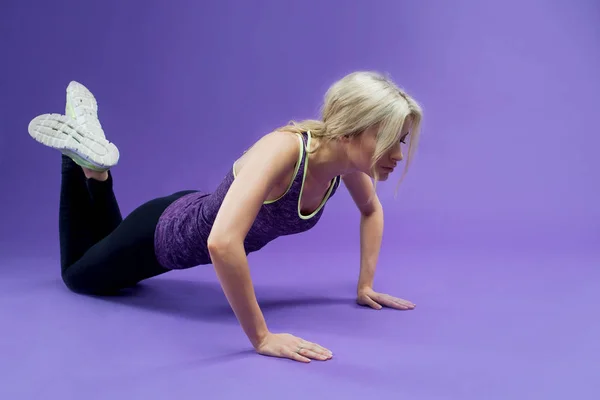 Jeune femme faisant push-ups séance d'entraînement fitness en studio — Photo