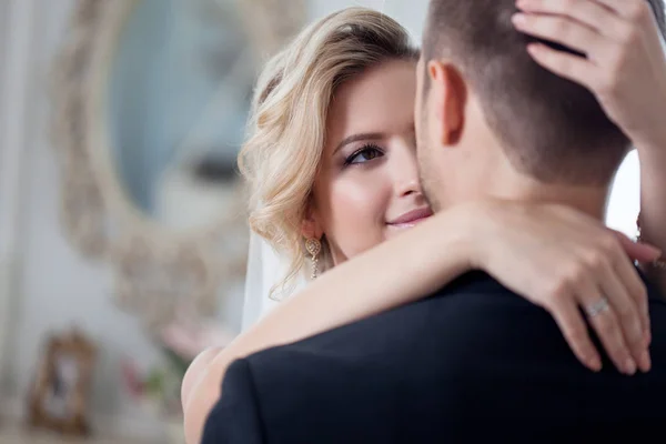 Umarmung am Hochzeitstag. schöne Braut umarmt Bräutigam im Nacken — Stockfoto