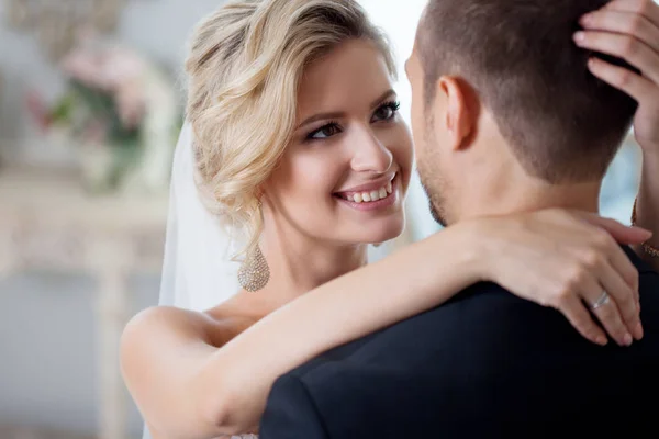 Umarmung am Hochzeitstag. schöne Braut umarmt Bräutigam im Nacken — Stockfoto