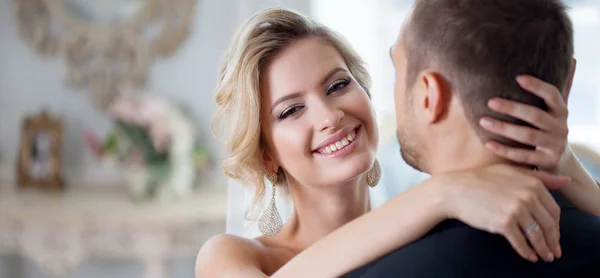 Omfamna på bröllopsdag. Vackra bruden omfamnande brudgummen i nacken — Stockfoto