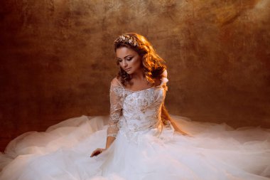 Güzel kız gelin oturan kat, portre altın tonlarda, parlama etkileri üzerinde lüks gelinlik