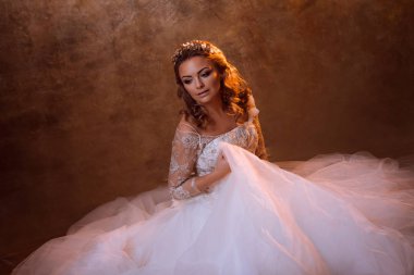 Güzel kız gelin oturan kat, portre altın tonlarda, parlama etkileri üzerinde lüks gelinlik