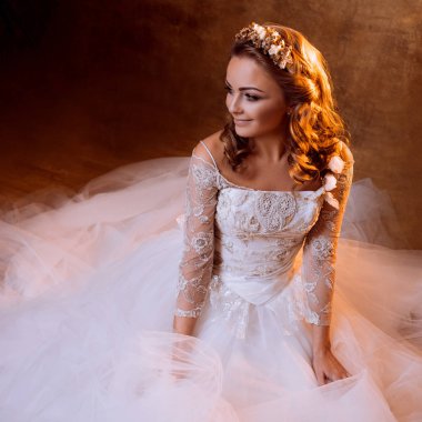 Çok mutlu kız gelin portre altın tonlarda katta oturan lüks gelinlik