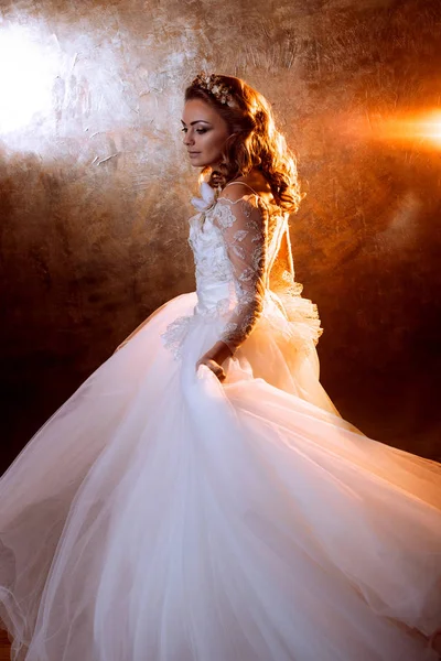 Hermosa novia chica en lujoso vestido de novia, retrato en tonos dorados, efectos de deslumbramiento — Foto de Stock