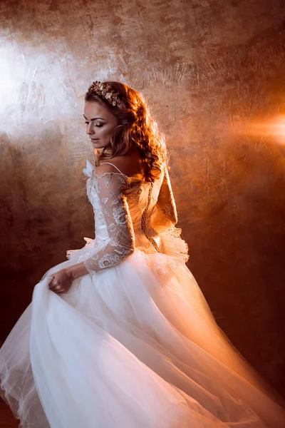 Schöne Braut im luxuriösen Hochzeitskleid, Porträt in goldenen Tönen, Effekte der Blendung — Stockfoto