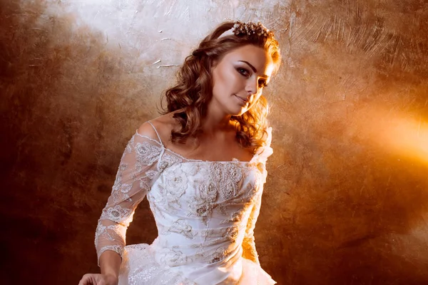 Beautiful girl bride in luxurious wedding dress, portrait in Golden tones, effects of glare — Stock Photo, Image