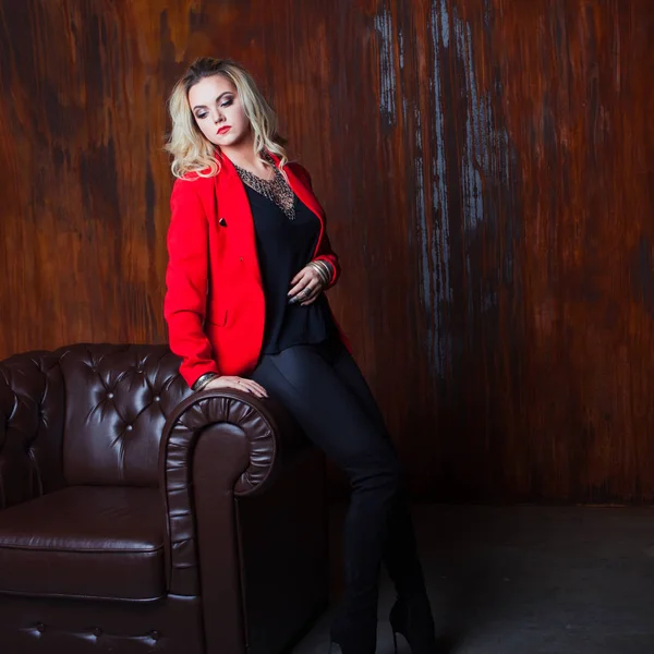 Junge und attraktive blonde Frau in roter Jacke, Hintergrund Grunge rostige Wand — Stockfoto